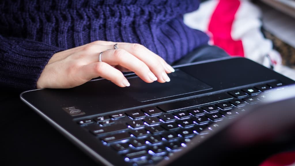 A person using a black laptop computer